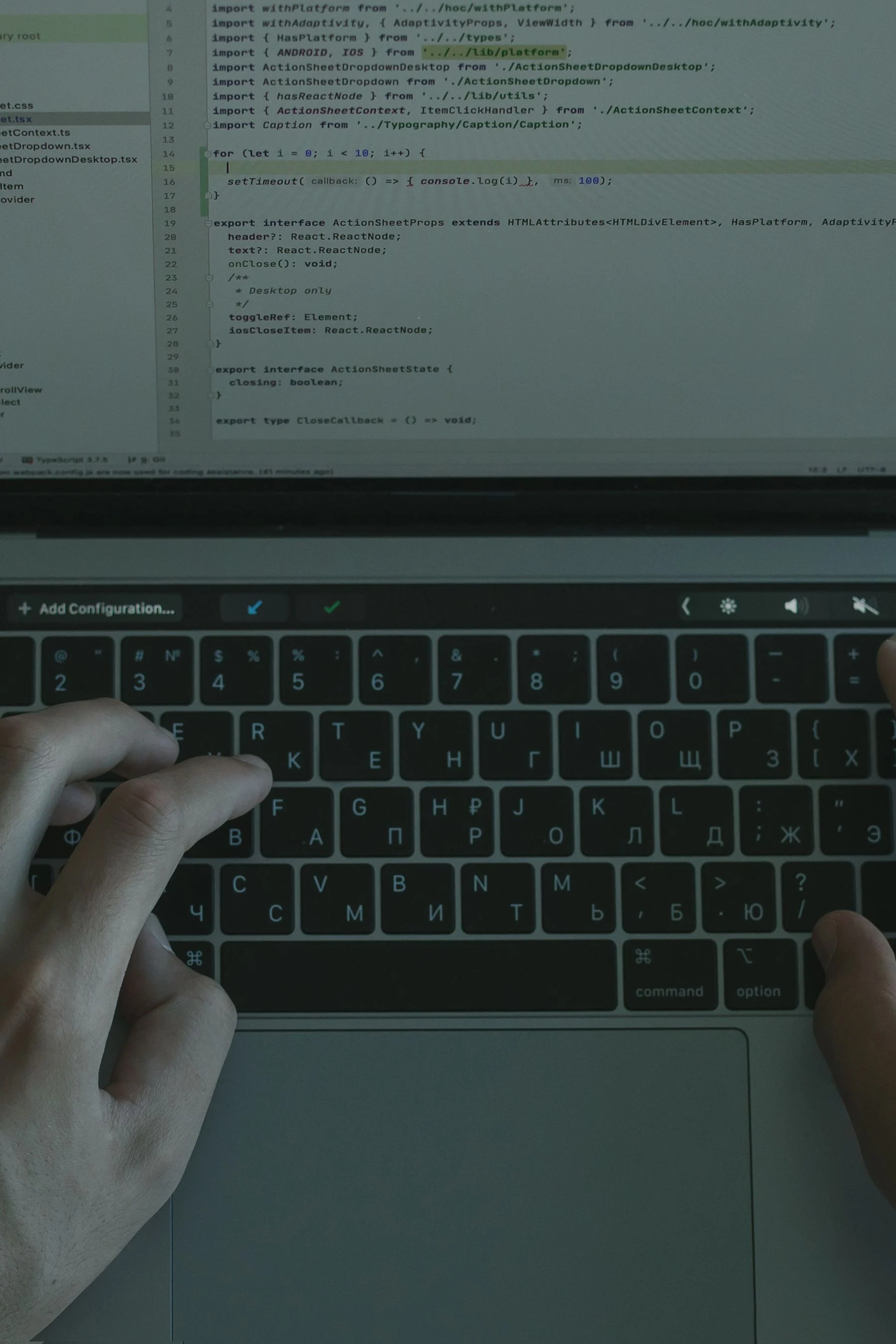 Hands working on website code on a laptop